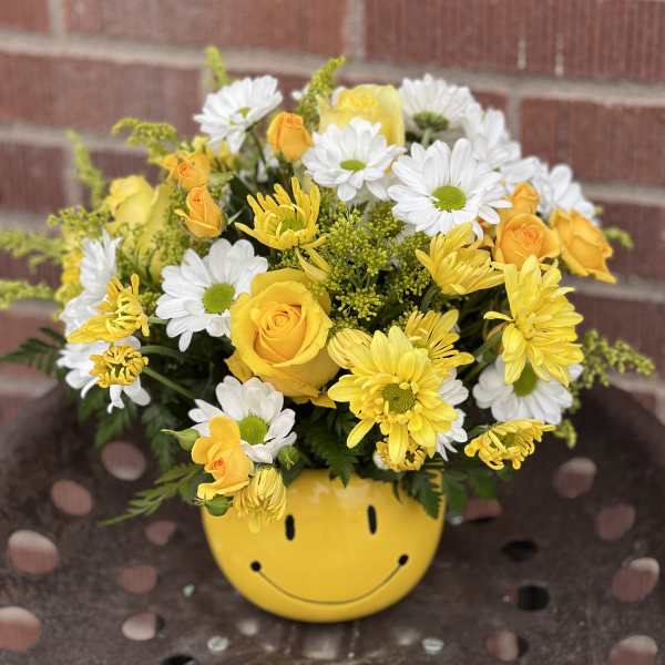 Yellow and white bouquet in a smiley-face pot