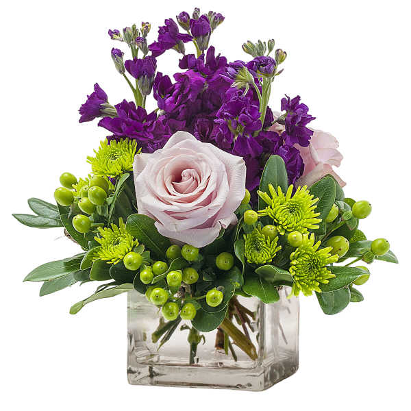 Purple and pink floral arrangement in a clear glass cube vase
