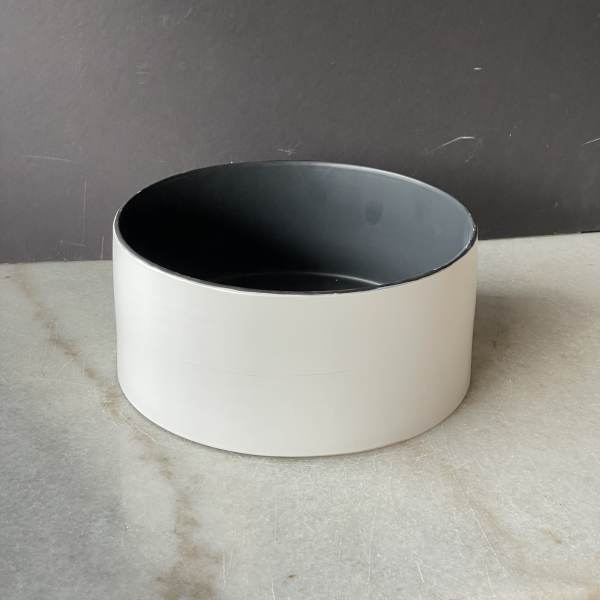 Empty round white planter with a dark interior