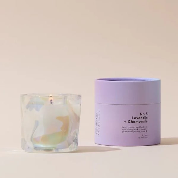 Lavender candle in a glass vessel beside its box
