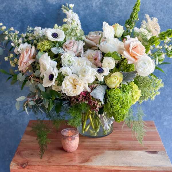 Mixed bouquet of white and blush flowers in a glass vase