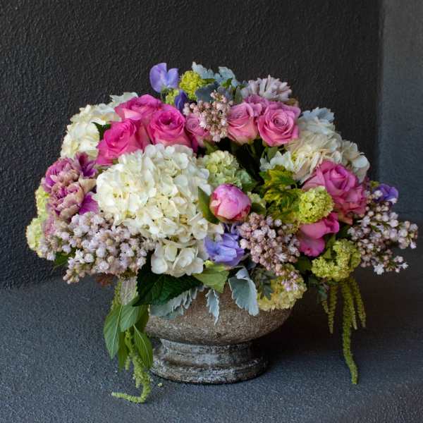 Mixed bouquet of pink roses and white hydrangeas in a stone vase