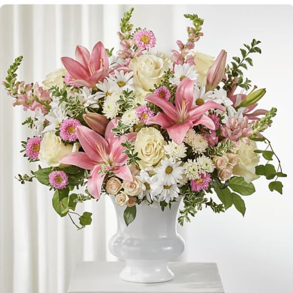 Pink lilies and mixed white and pink flowers in a white vase