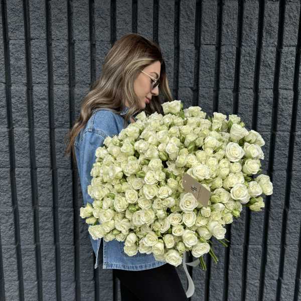 Woman holding a large bouquet of white roses