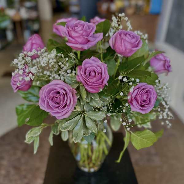 Bouquet of pink roses with baby's breath in a glass vase
