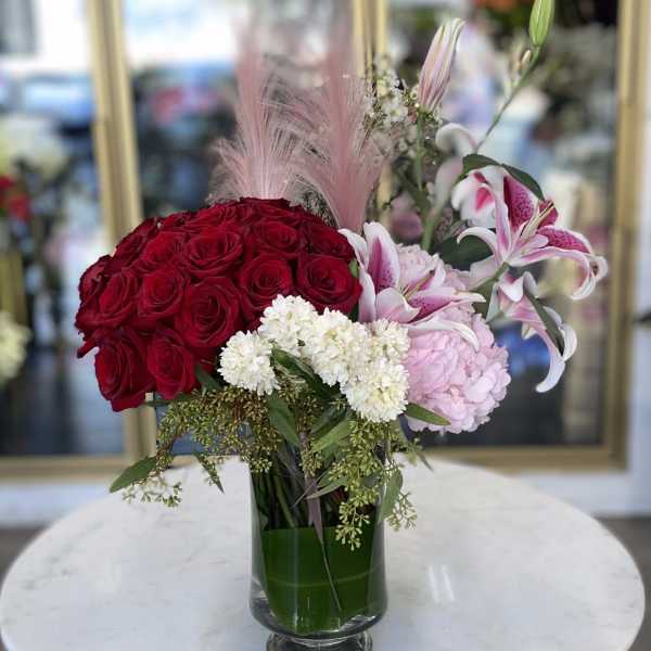 Red roses and pink lilies in a glass vase