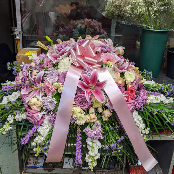 Large pink and lavender floral spray with a satin ribbon bow