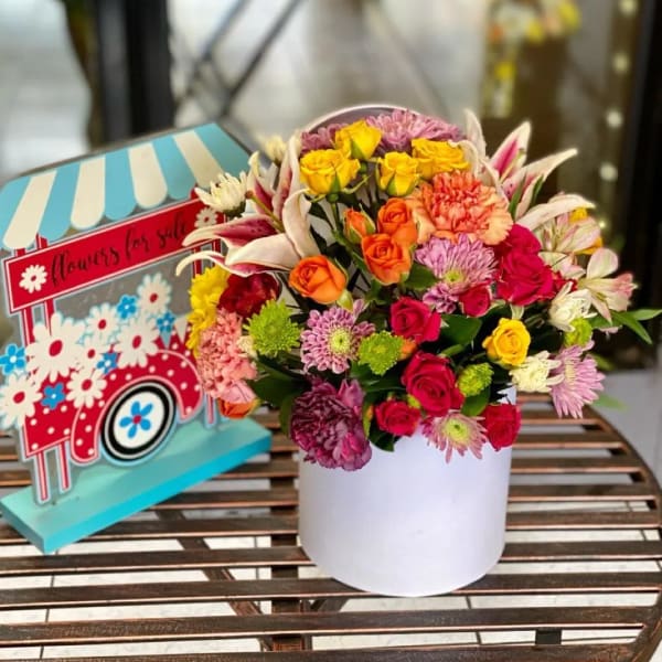 Colorful mixed bouquet in a white box with roses and lilies