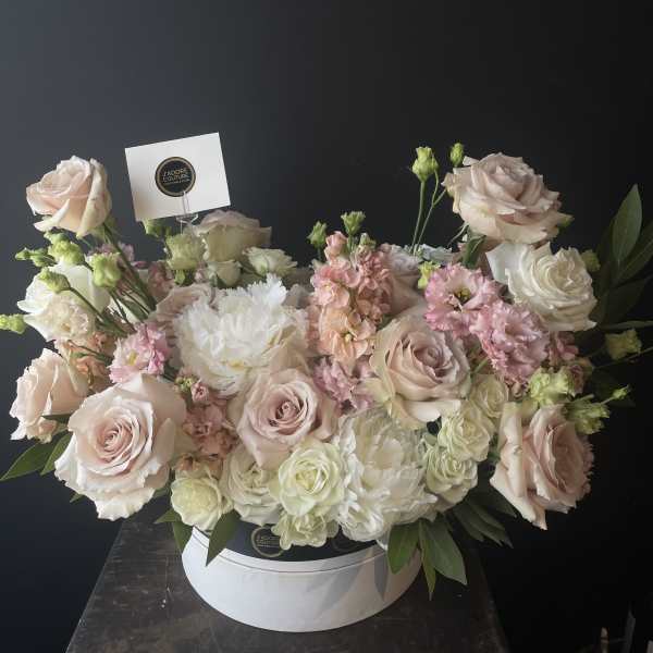 Blush and white roses with pink blooms in a white hat box
