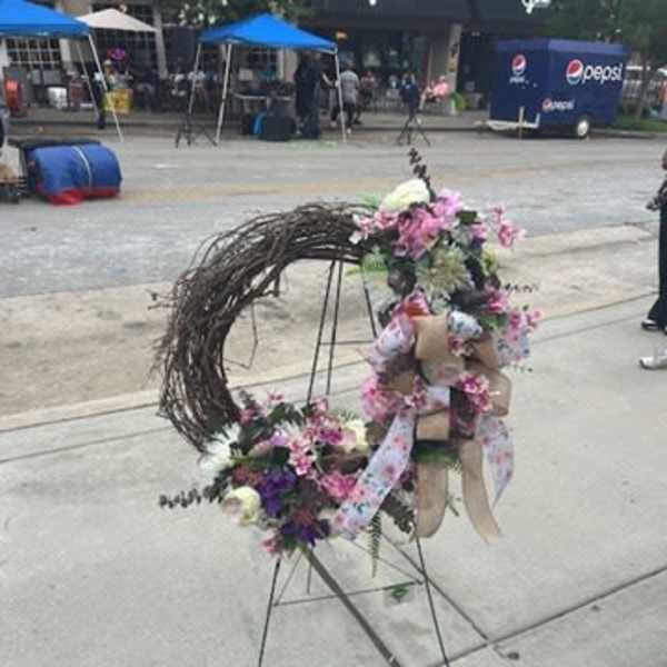 Floral standing wreath with pink and white flowers on a metal easel