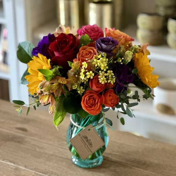 Colorful mixed bouquet in a turquoise glass vase