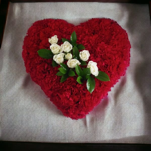 Heart-shaped red floral arrangement with white roses in the center
