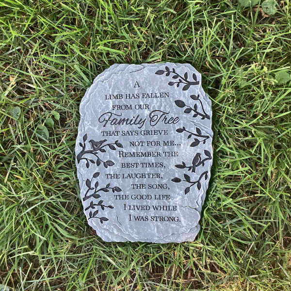 Memorial stone with engraved text lying in grass
