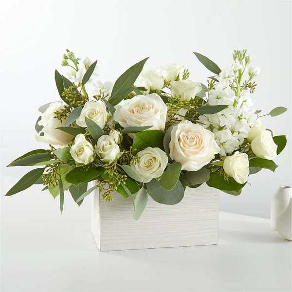 White roses and white blooms arranged in a white box