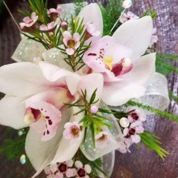 White and pale pink orchid arrangement with small pink blossoms