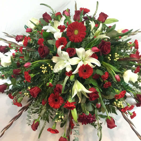 Large red and white floral spray with roses, lilies, and gerbera daisies