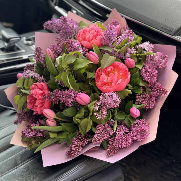 Pink peonies and lilac blooms in pink wrapping