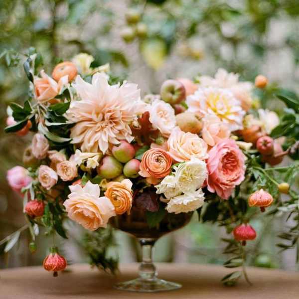 Pastel floral arrangement in a glass compote vase