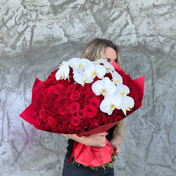 Large bouquet of red roses with white orchids wrapped in red paper