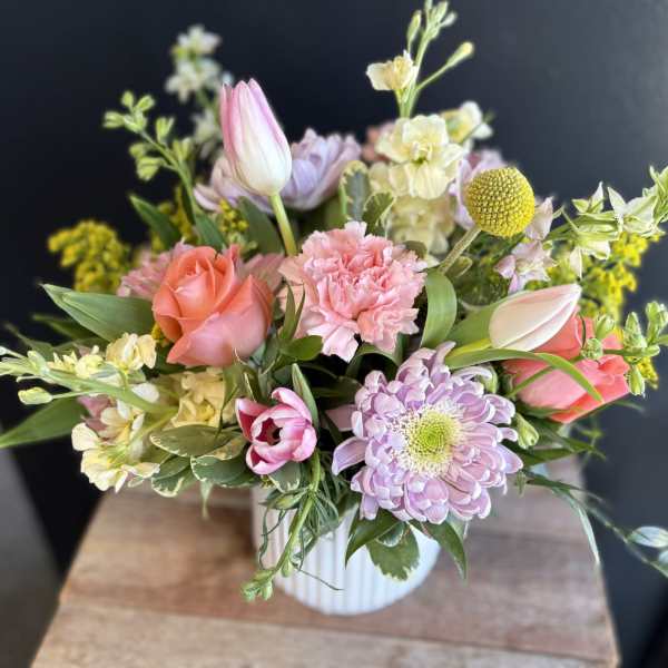 Pastel bouquet in a white ribbed vase with roses, tulips, and chrysanthemums