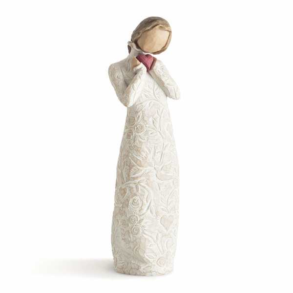 Cream-colored figurine of a girl holding a pink heart