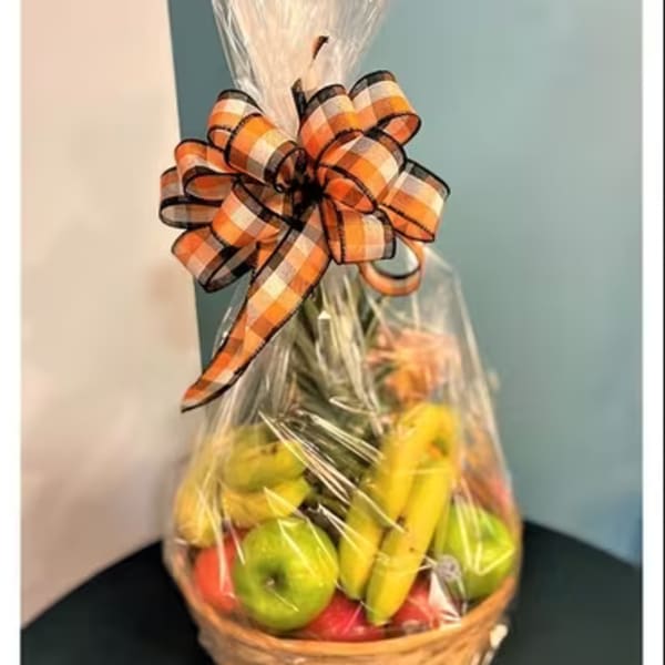 Basket of fruit wrapped in clear cellophane with a plaid bow