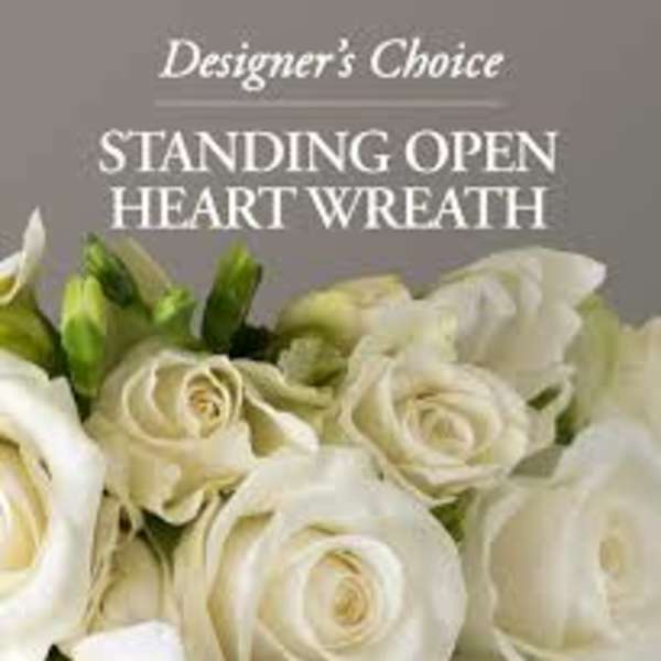 White roses and calla lilies arranged in a standing heart wreath.