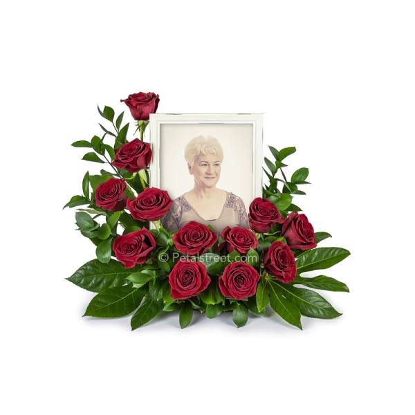 Framed portrait surrounded by red roses and greenery
