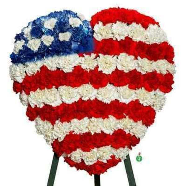 Heart-shaped floral tribute in red, white, and blue carnations