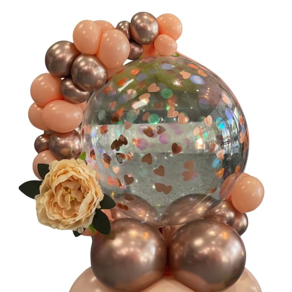 Balloon arrangement with a clear confetti balloon and a peach flower accent