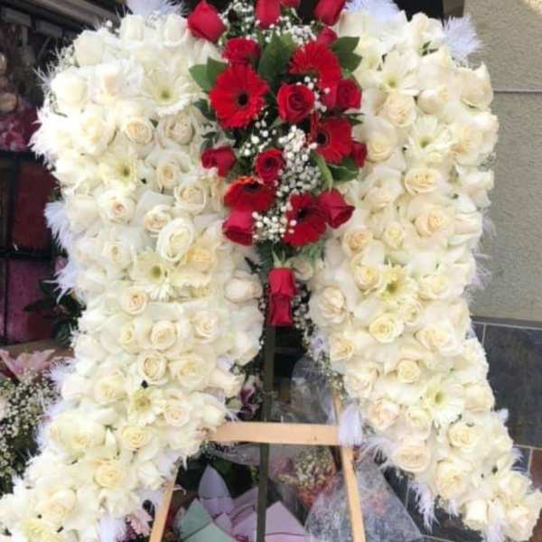 Large standing floral wreath of white and red roses on an easel