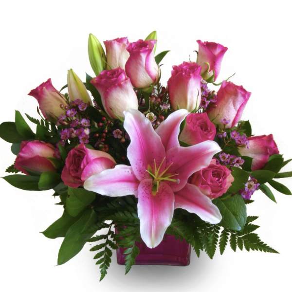 Pink roses and a lily in a glass vase
