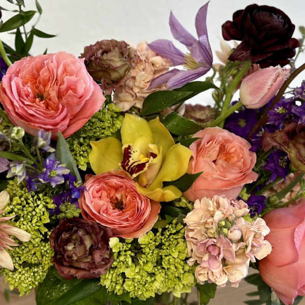 Mixed bouquet with pink roses, purple flowers, and a yellow orchid