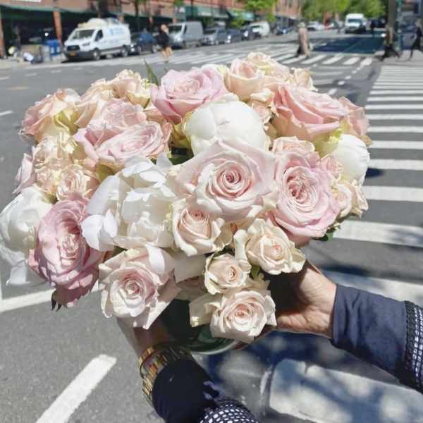 Handheld bouquet of pale pink and white roses