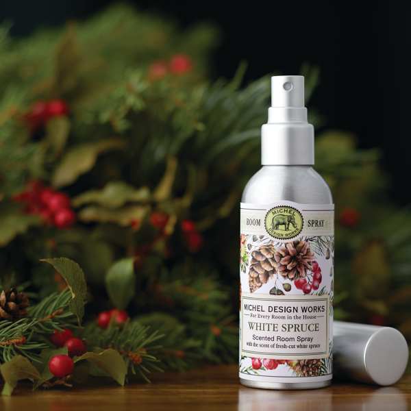 Bottle of white spruce scented room spray with a floral holiday background