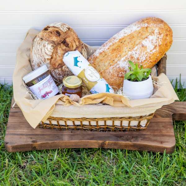 Gift basket with bread, jam, and a small potted succulent