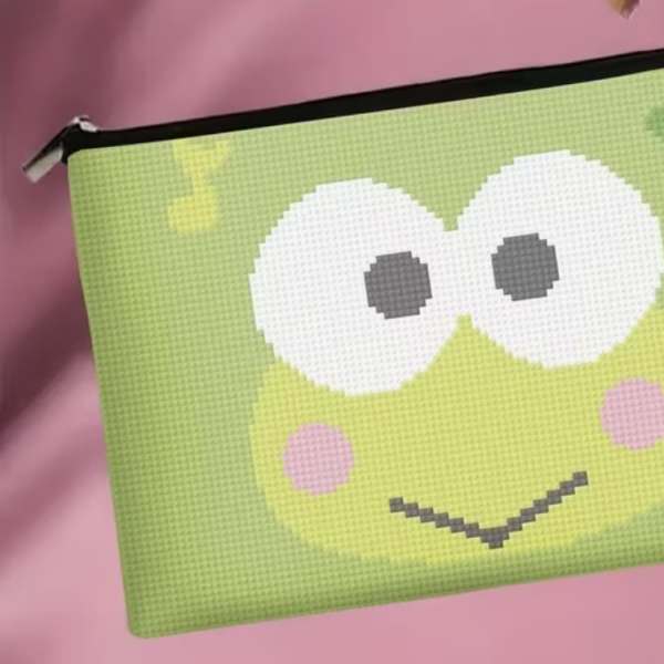 Green frog-face pouch on a pink background