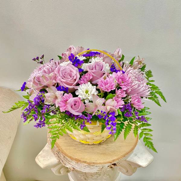 Pink roses and mixed daisies in a woven basket