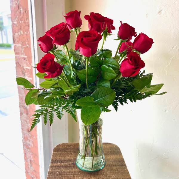 Red roses arranged in a clear glass vase