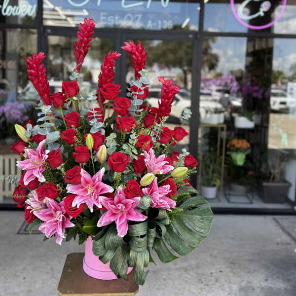 Tall bouquet of red roses and pink lilies in a pink vase