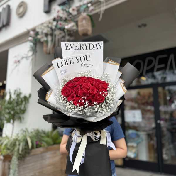 Bouquet of red roses with baby's breath and black-and-white wrapping