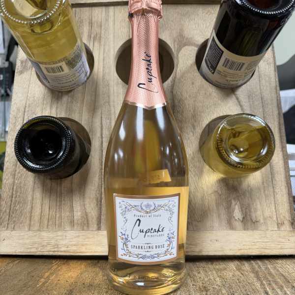 Five bottles of sparkling wine arranged in a wooden carrier