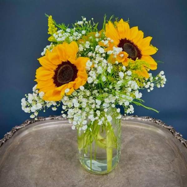 Sunflowers and white baby's breath in a clear glass vase