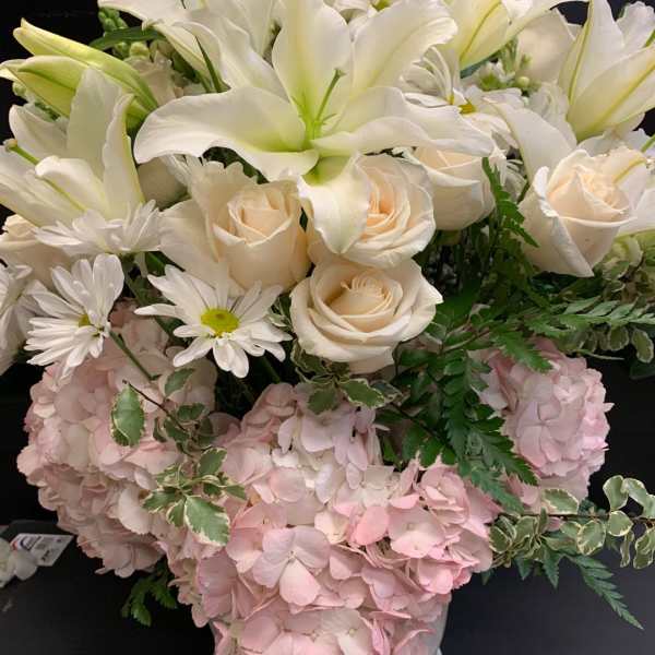 White lilies and cream roses in a vase with pink hydrangeas