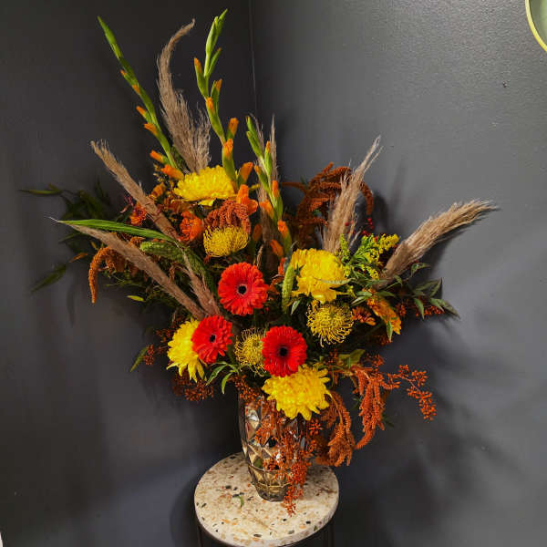 Arrangement of red and yellow flowers in a faceted glass vase