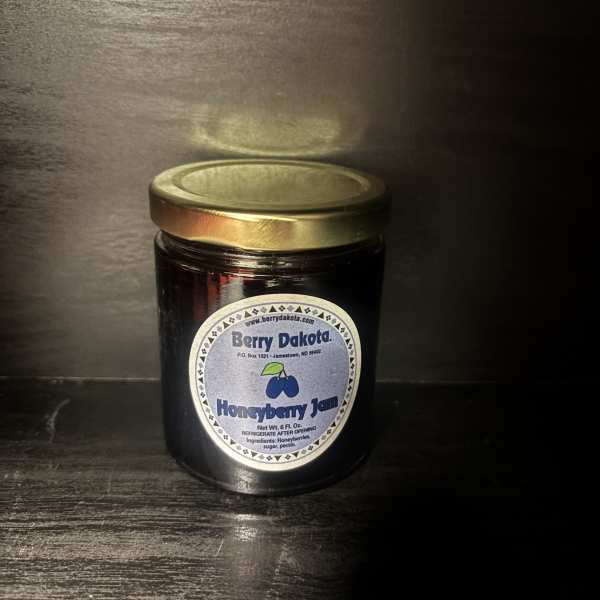 Jar of honeyberry jam with a gold lid