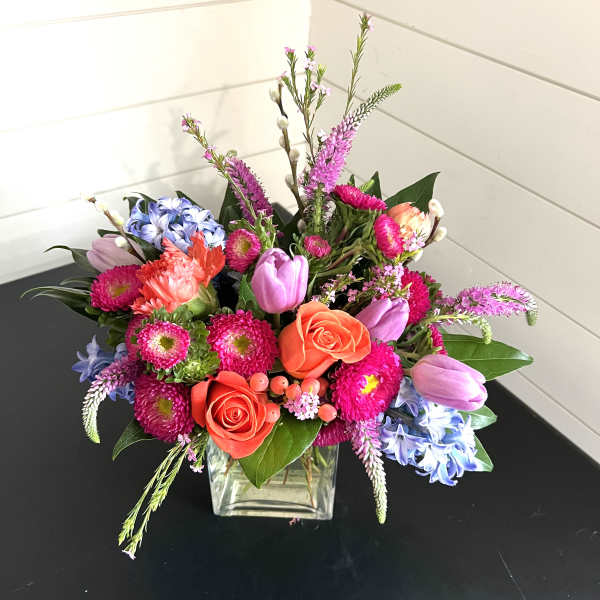 Colorful mixed bouquet in a square glass vase