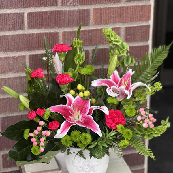 Pink lilies and carnations in a white vase