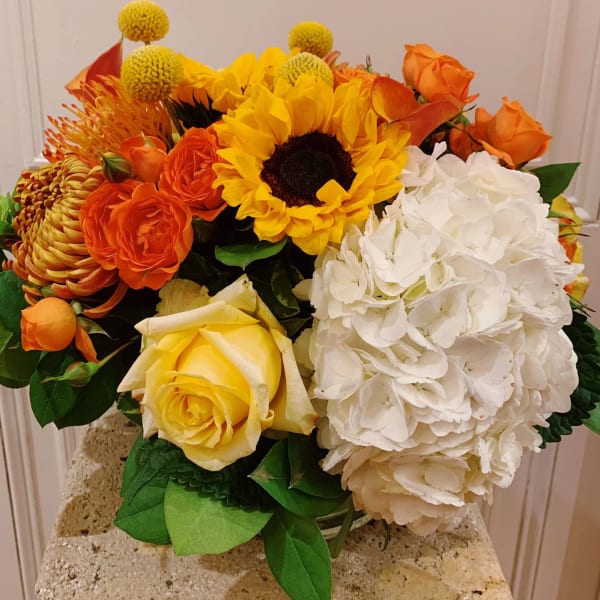 Bouquet of sunflowers, orange roses, and white hydrangeas