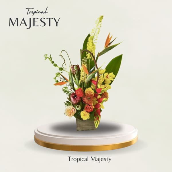 Tall tropical bouquet with orange bird-of-paradise and mixed blooms in a square vase
